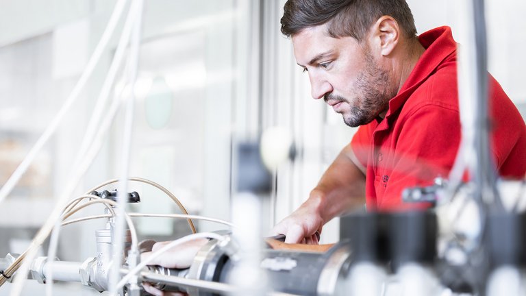 Mitarbeiter macht Karriere bei Scherzinger Pumpen Aufnahme eines Mitarbeiters bei der Arbeit, der Karriere bei der Scherzinger Pumpen GmbH macht.